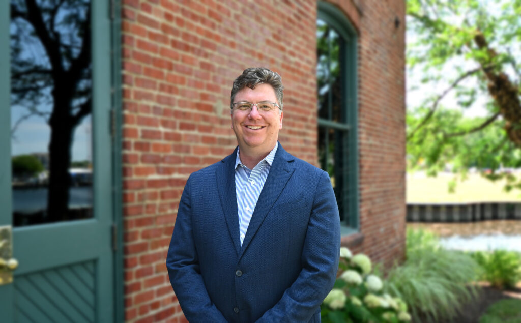 a man standing in front of a brick building