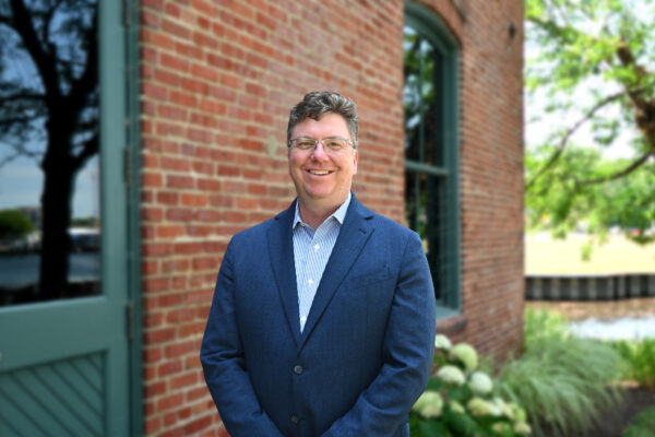 a man standing in front of a brick building