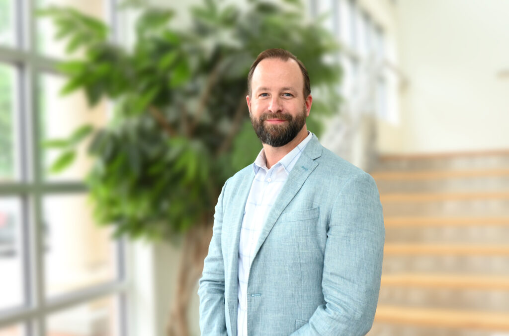 a man in a suit standing in front of a window