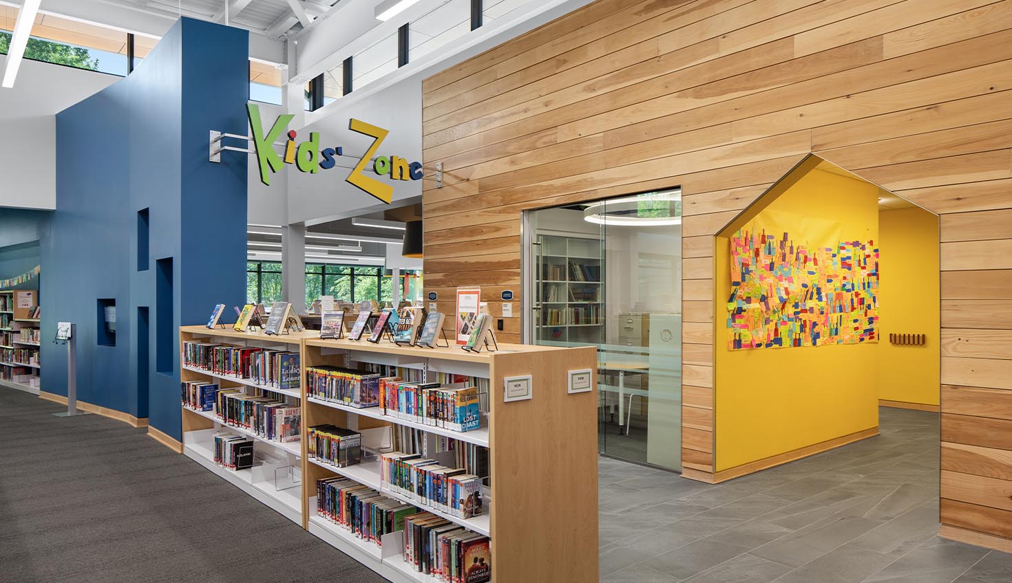 a library filled with lots of books next to a wooden wall