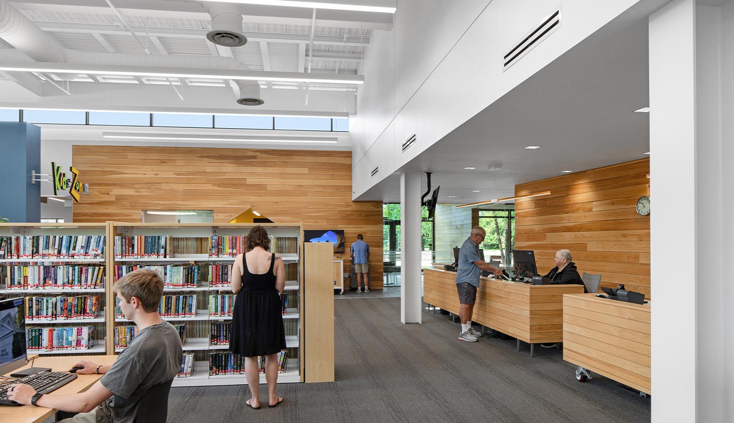 a man sitting at a computer in a library