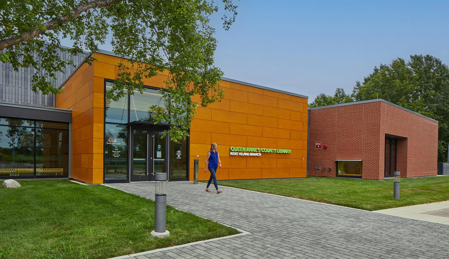 a person walking down a sidewalk in front of a building