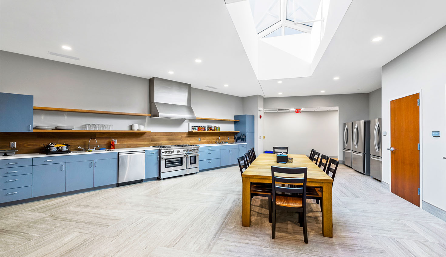 a large kitchen with blue cabinets and a skylight