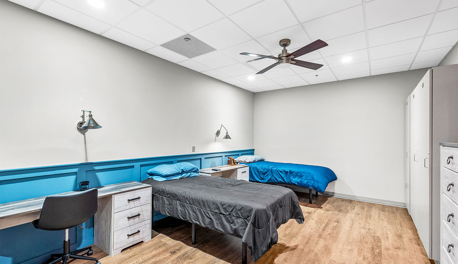 a bedroom with two beds and a desk