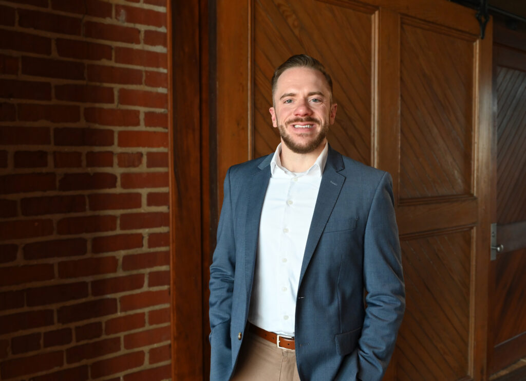 a man standing in front of a brick wall