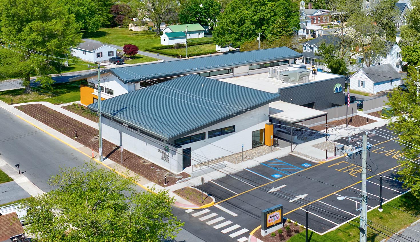 an aerial view of a building with a parking lot in front of it