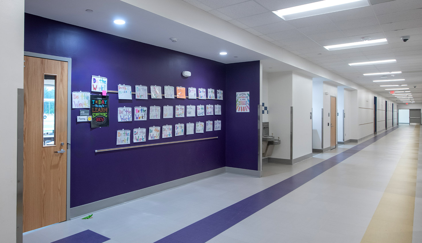 a long hallway with purple walls and white floors