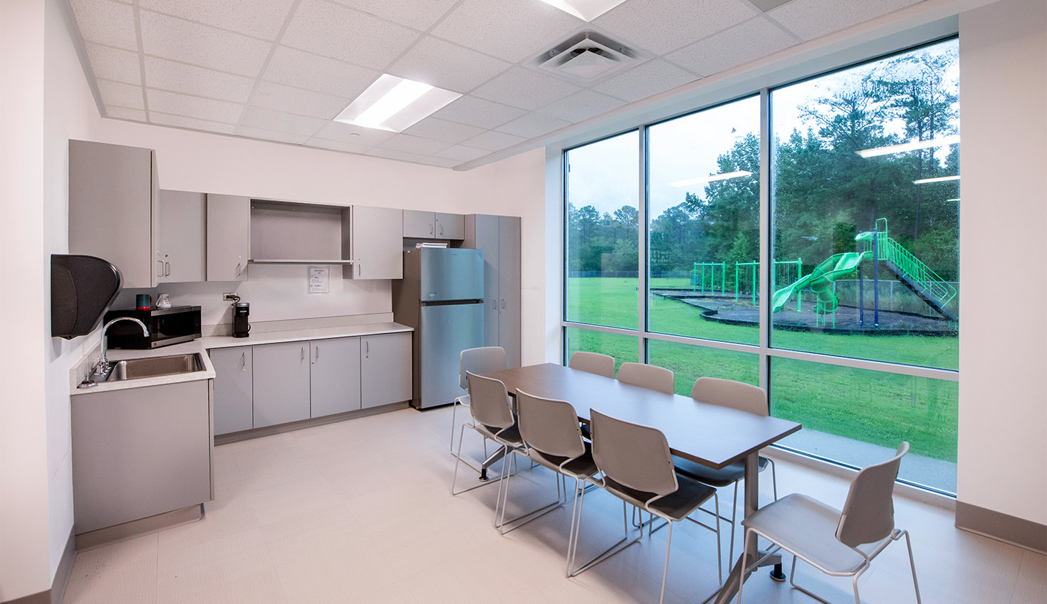 a kitchen with a table and chairs near a window