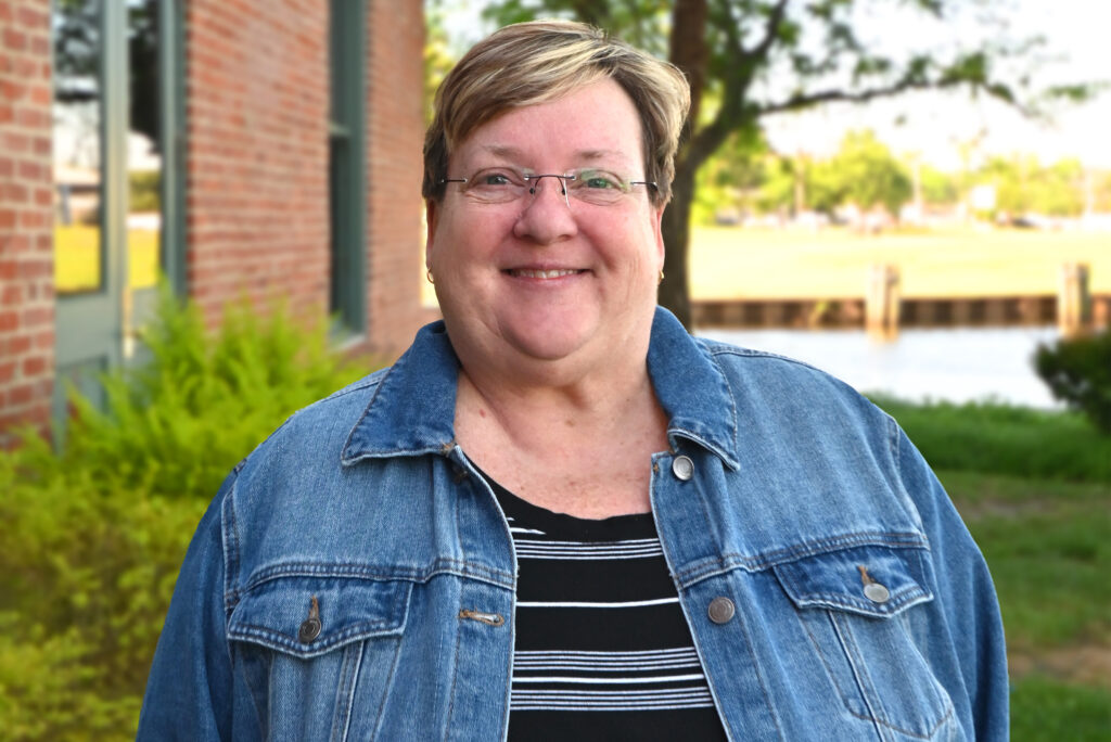 a woman standing in front of a brick building