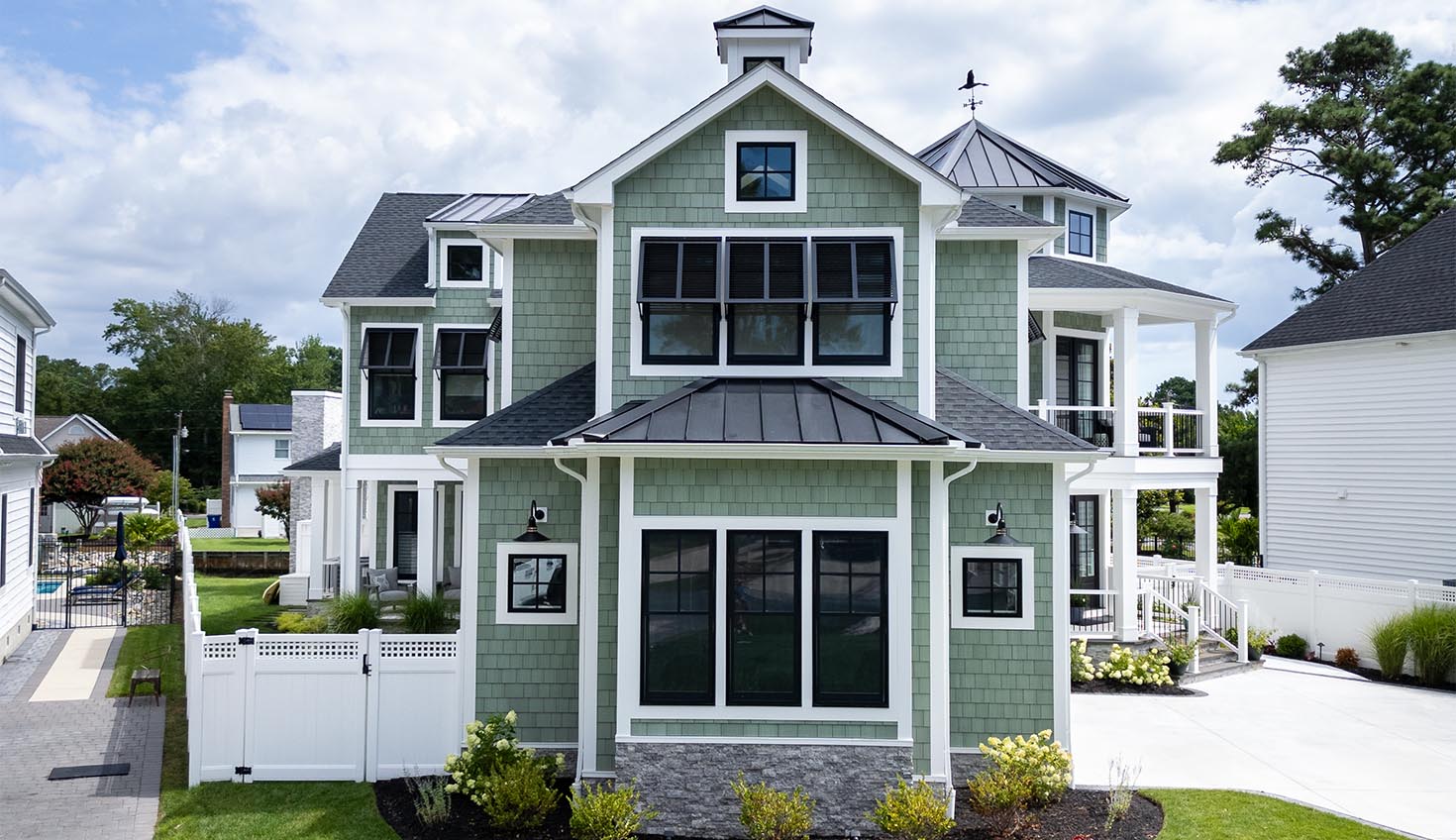 a green house with a black roof and white trim