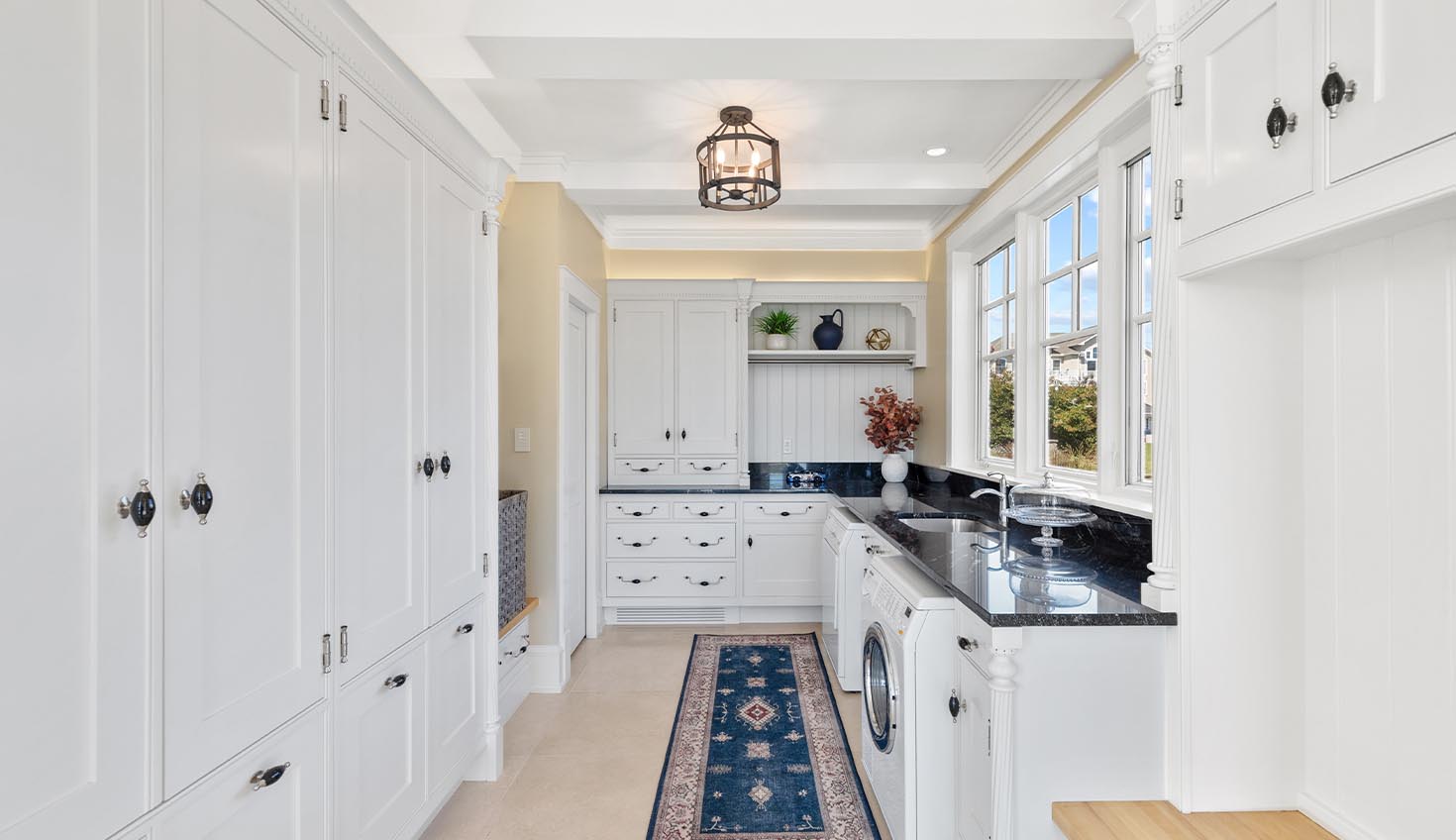 a kitchen with white cabinets and black counter tops
