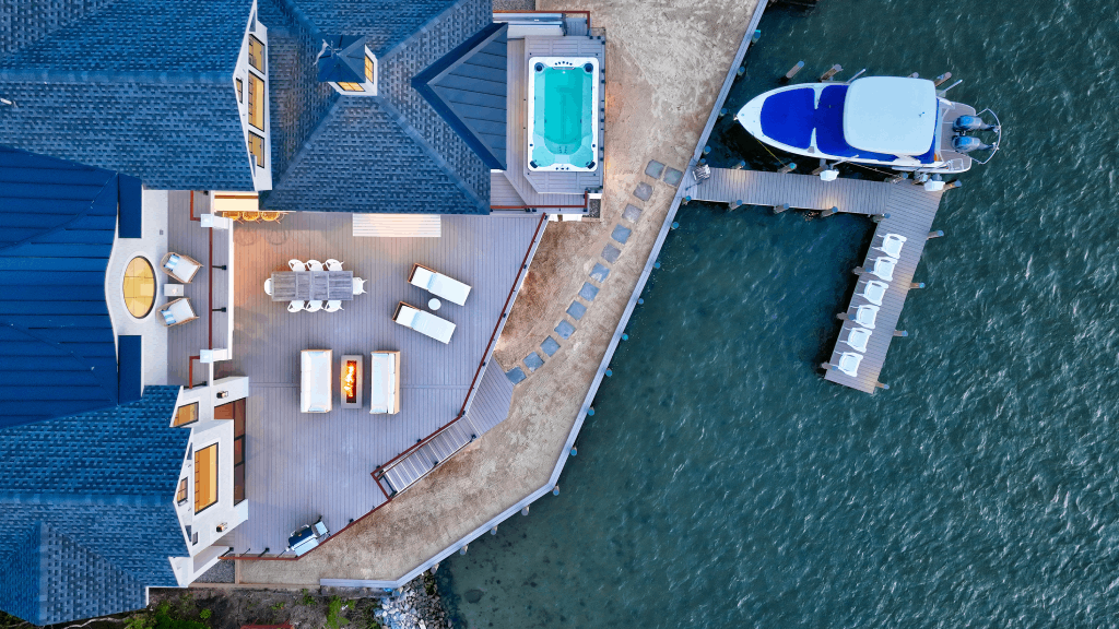 an aerial view of a house next to a body of water