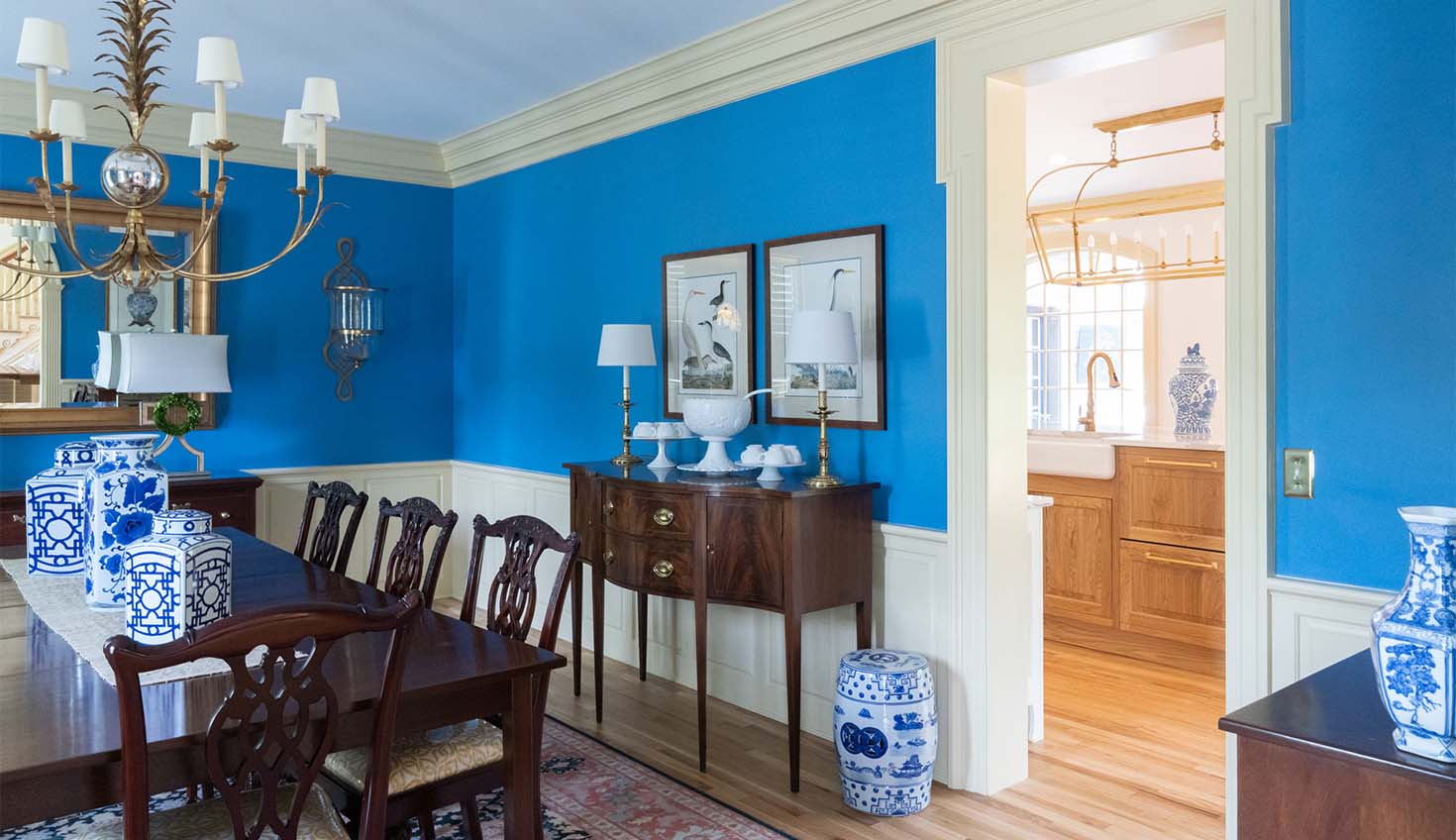 a dining room with blue walls and a chandelier