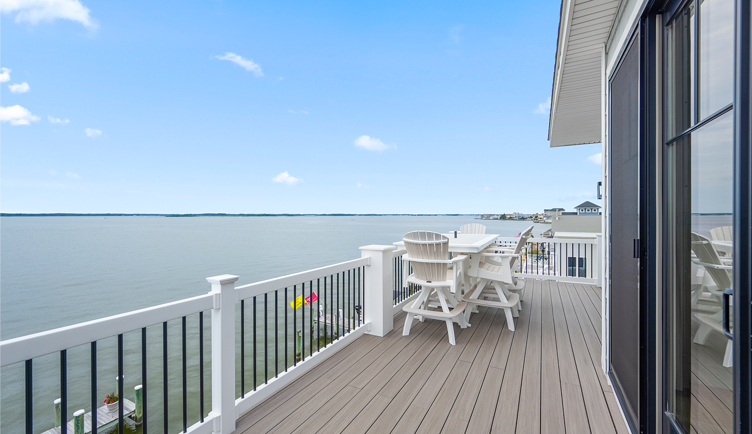 a balcony with a table and chairs overlooking the water