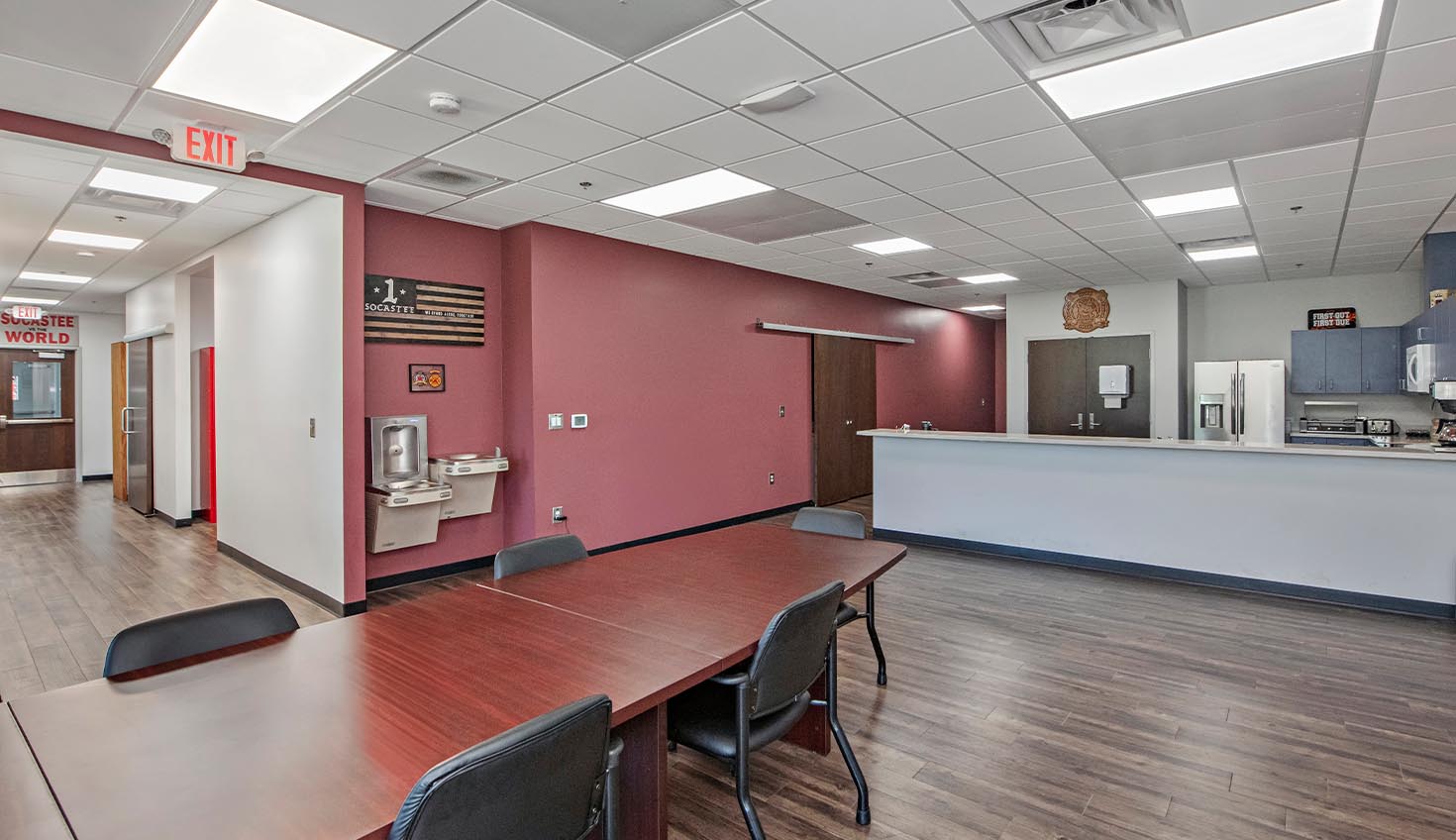 a room with a table, chairs, and a refrigerator