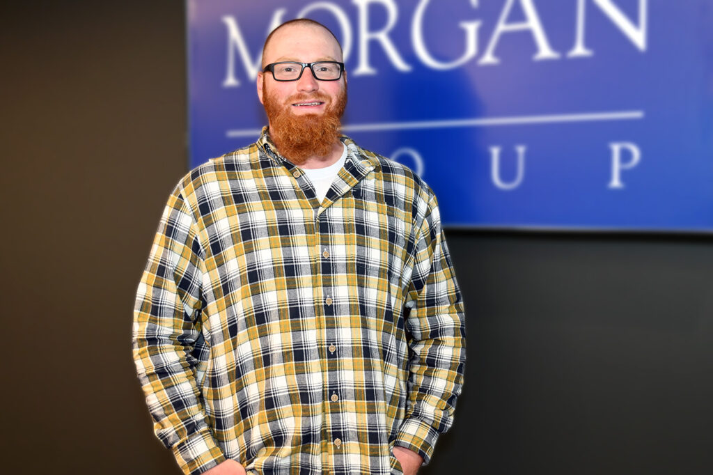 a man standing in front of a morgan group sign