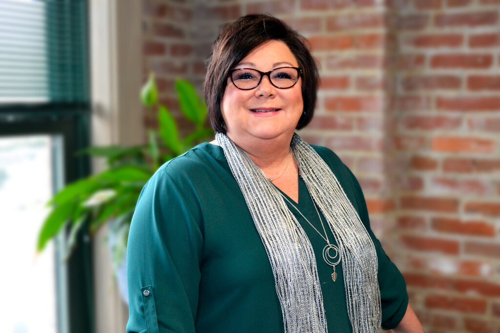 a woman standing in front of a brick wall