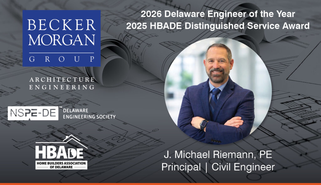 a man in a suit and tie standing in front of blueprint