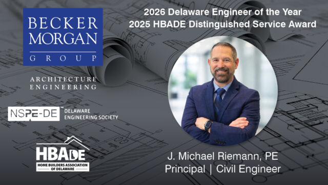 a man in a suit and tie standing in front of blueprint