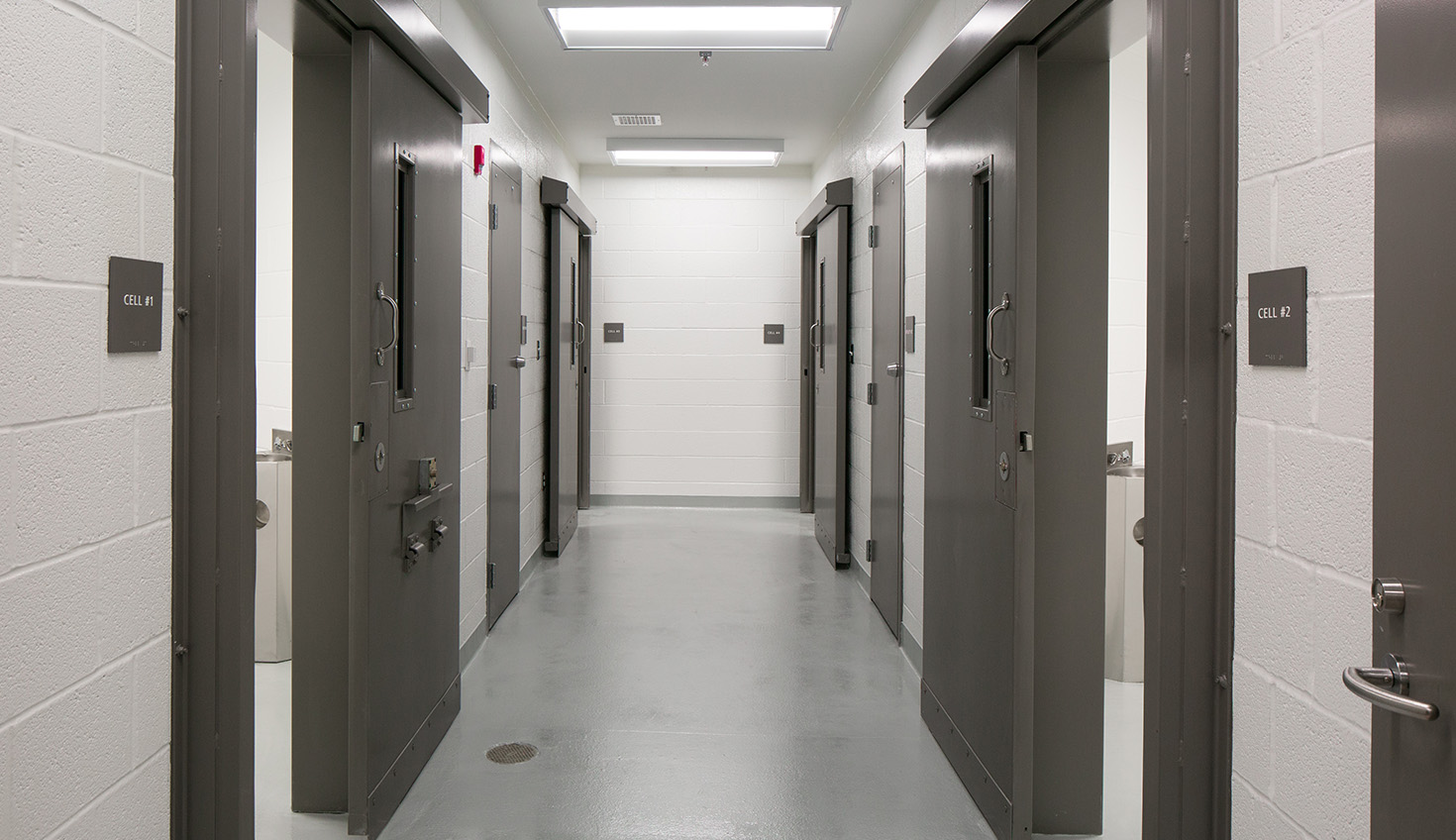 a long hallway with several doors leading to another room