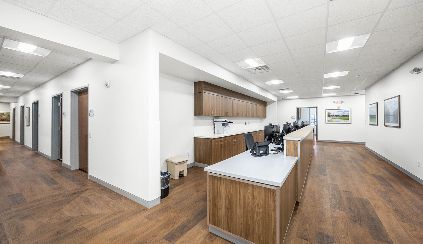 an empty office with wood floors and white walls