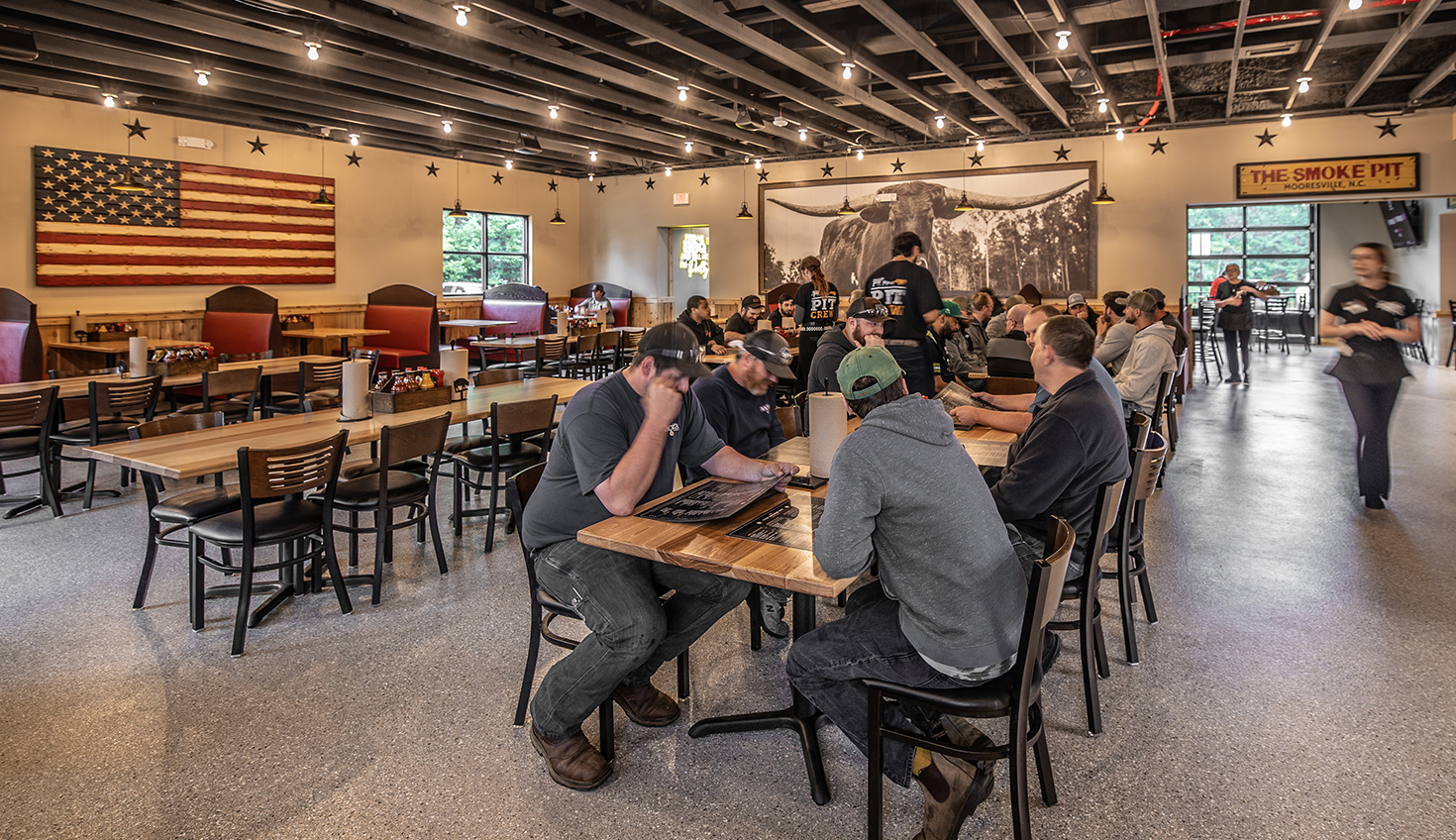 a group of people sitting at tables in a restaurant